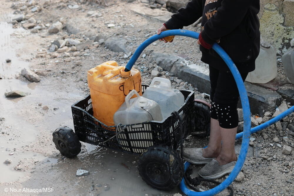 Un niño palestino recoge agua en la ciudad de Beit Lahia, al norte de la Franja de Gaza, Palestina.