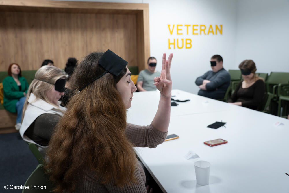Los veteranos, junto con algunos compañeros, cónyuges o familiares cercanos, participan en un juego como parte de las actividades de ocio que ofrece el centro Veteran Hub en Vinnytsia.