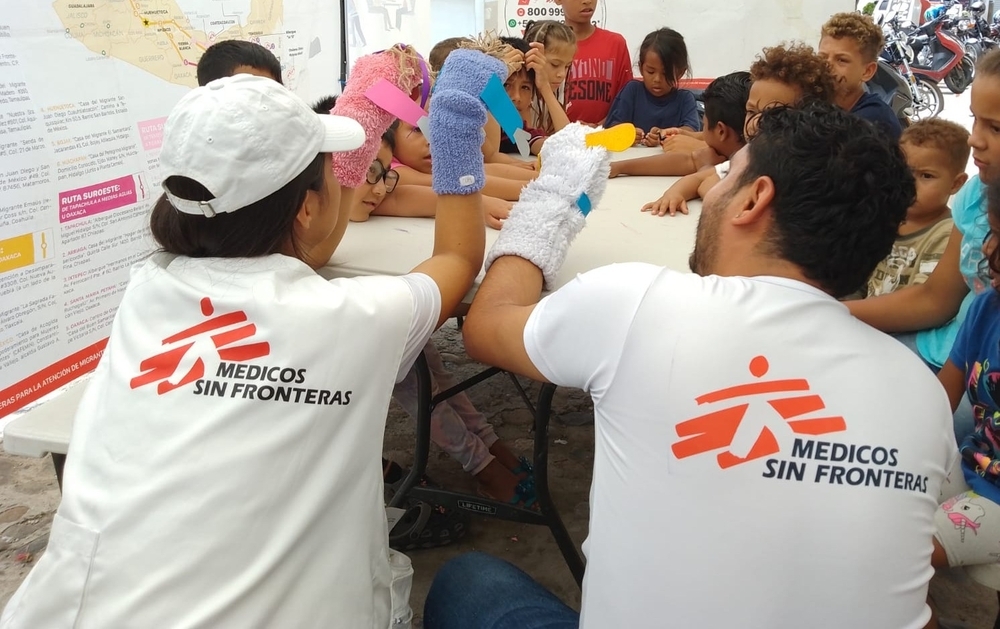 Dos miembros del equipo de promoción de la salud dirigieron una actividad educativa con niños migrantes. Mediante técnicas lúdicas, como títeres, les brindaron información sobre el autocuidado durante el viaje migratorio.