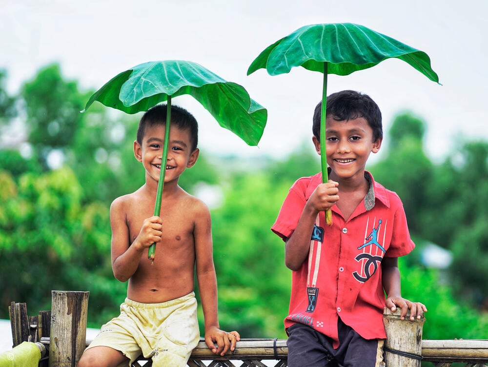 En junio de 2025, el fotoperiodista rohingya Zia Sahat Hero y el fotógrafo de MSF Australia Victor Caringal realizaron una serie de fotografías para mostrar cómo los rohingya se han adaptado a la vida cotidiana en los campos de refugiados de Kutapalong, cerca de Cox's Bazaar, Bangladesh. Los juegos y la imaginación de los niños crean momentos de alivio frente a los retos diarios en los campos. Su visión de un futuro mejor no solo es una expresión de esperanza, sino también una forma de gestionar y procesar las difíciles realidades que les rodean. Mientras caminábamos por los campamentos, vimos que había niños por todas partes, riendo, jugando y, a veces, siendo regañados. Aportaban vida a los campamentos y momentos de alegría. Zia señaló que la razón por la que había tantos niños era el cierre de las escuelas debido a los recortes en las ayudas.