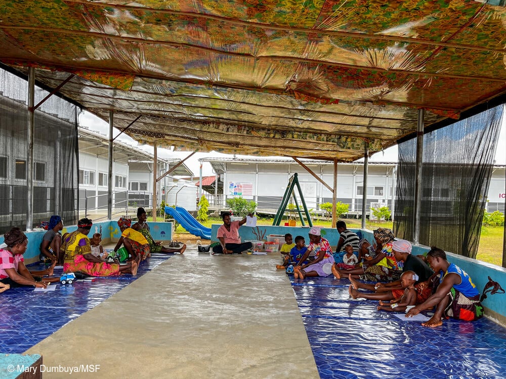 El consejero de MSF Kemoh Kargbo dirige una sesión de terapia de juego en grupo con niños y cuidadores en el parque infantil del Hospital Materno-Infantil de MSF en Kenema, Sierra Leona. 