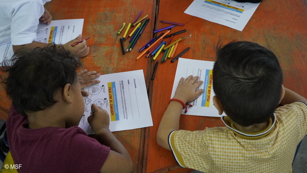 Niños pintando ilustraciones relacionadas con la prevención del dengue, adaptadas para niños y creadas por el equipo de MSF.