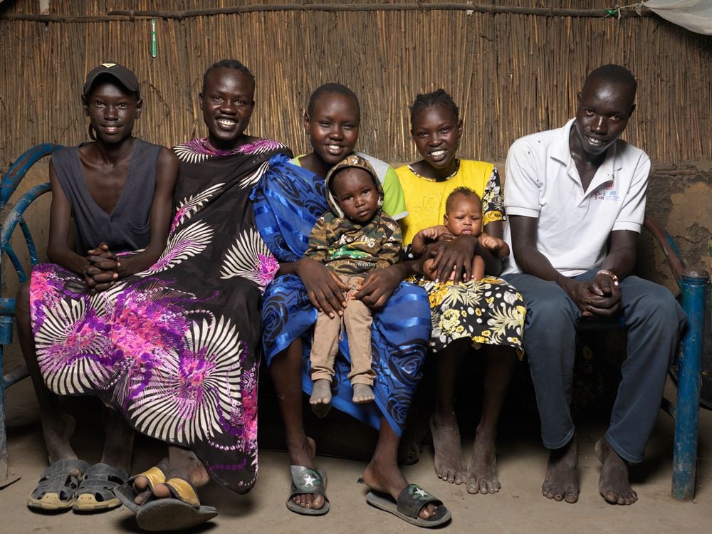 Nyasunday (en el centro de la foto) tiene 19 años y ha vivido en el campo de desplazados en Bentiu desde 2014. Fue diagnosticada con hepatitis E. Afortunadamente, después de recibir atención en el hospital de MSF, se pudo recuperar en casa con su familia. © Peter Caton
